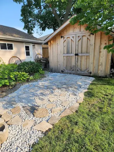 Flagstone path set in white stone leading to a wooden shed