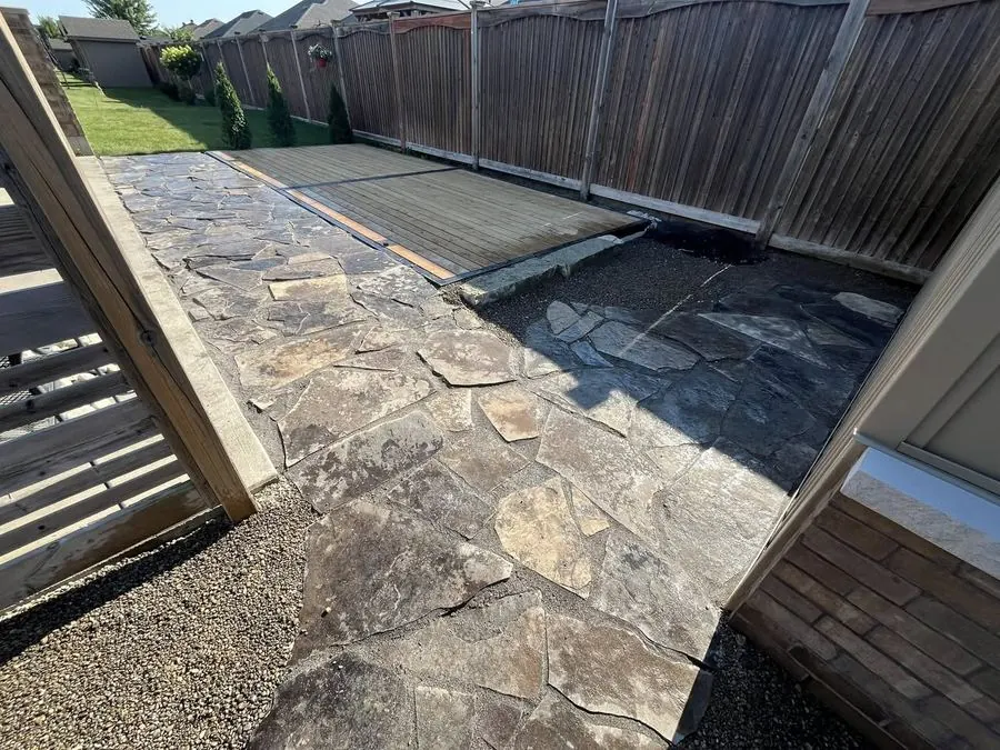 Flagstone side-yard patio laid along a wood fence