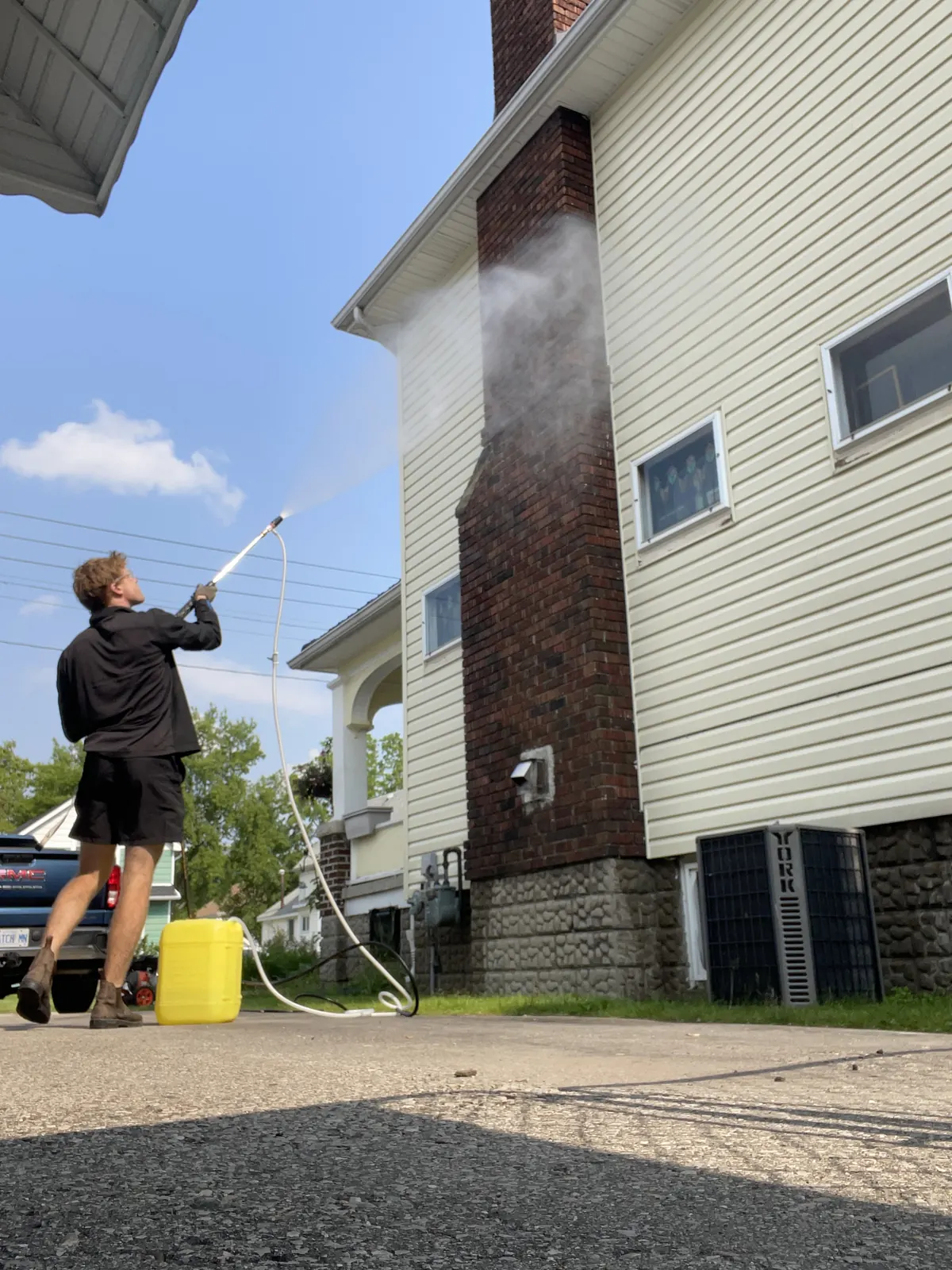 Bluewater crew pressure washing the siding of a two-storey home