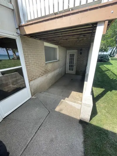 Walkout concrete patio under a deck after washing