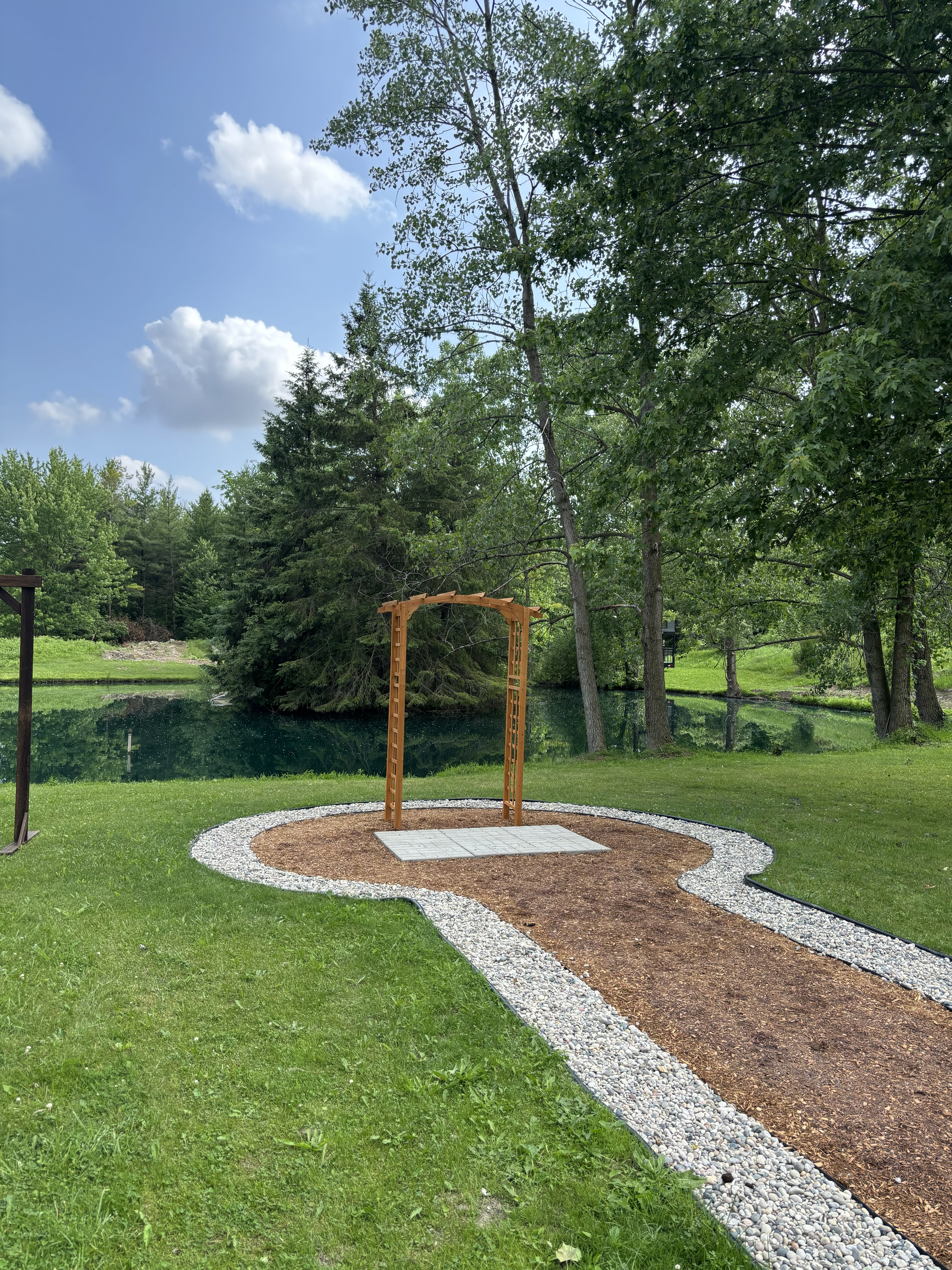 Wedding venue after Bluewater transformation — cedar arch, white gravel circle, flagstone pathway in Sarnia, Ontario